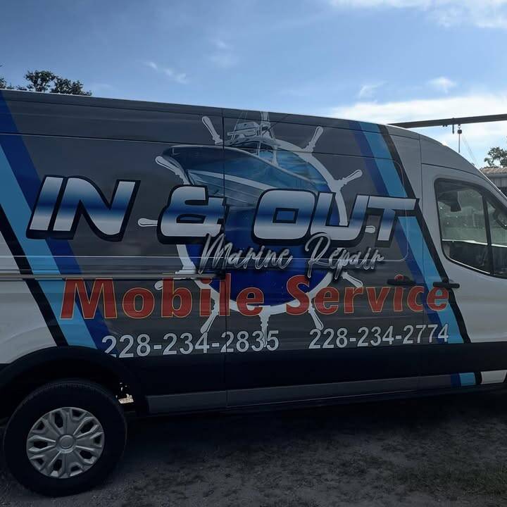 Side of the In & Out Marine Repair van, charcoal with blue stripes and the shop's logo