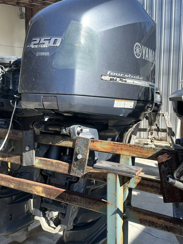Gray Yamaha 250 four-stroke outboard on an engine stand outside the shop